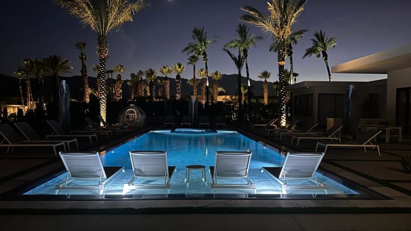 Pool loungers and water features at night